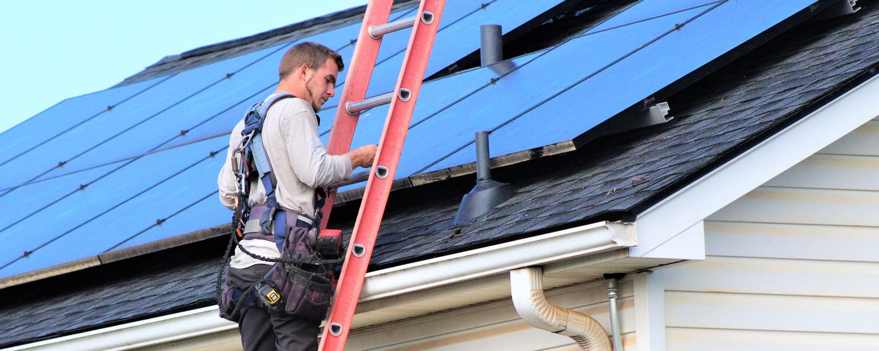Detail Solar technician climbing a ladder to the roof